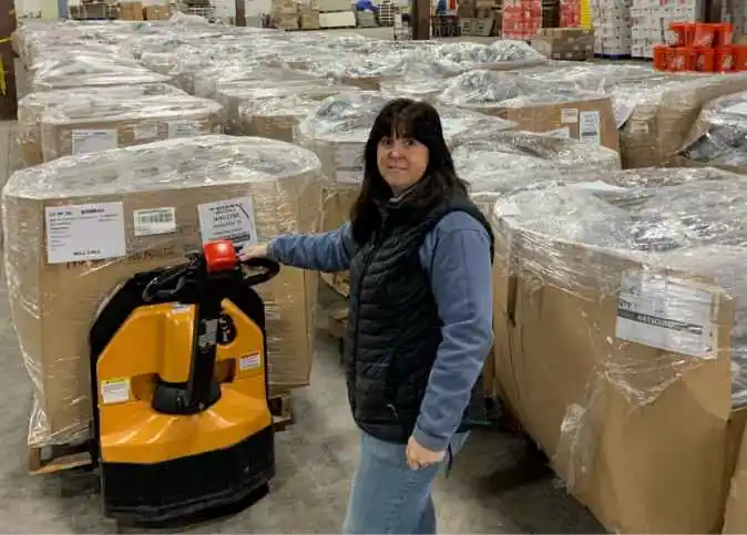 Woman moving pallet of goods