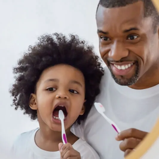 man brushing teeth with child