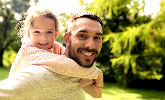 Man carrying young girl on back